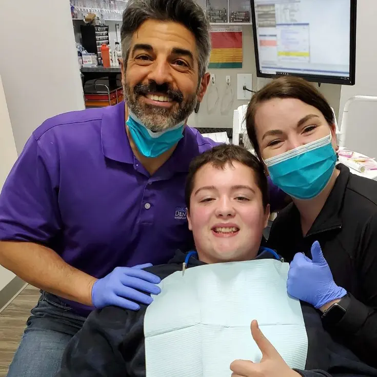 Image of Dr. Jason Tanoory with a member of his dental team and a patient