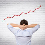 man turn away looking toward an upward moving graph